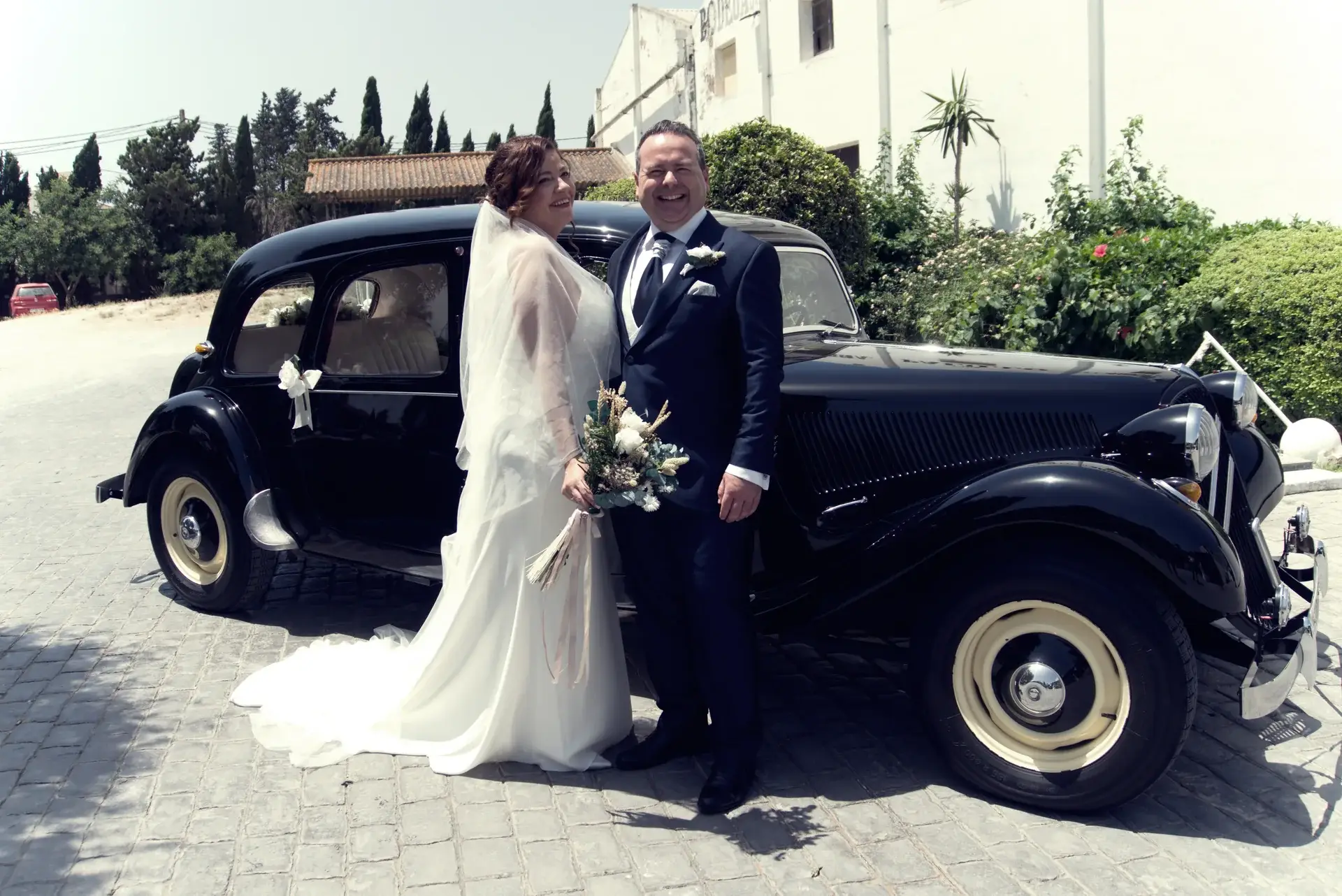 Pareja de novios junto a un coche clásico